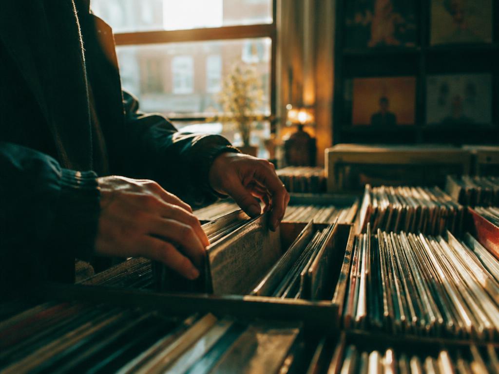 Hands browsing a collection of vinyl records